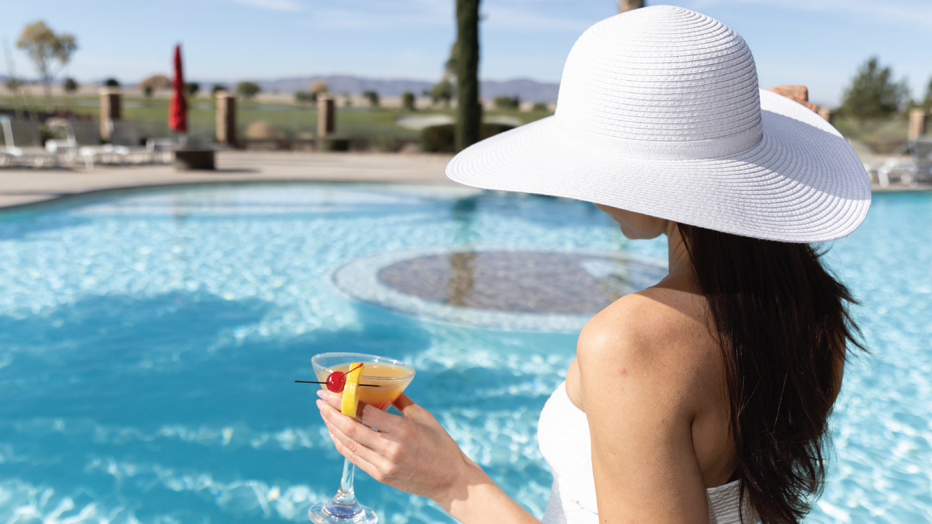 A Person Wearing A Hat By A Pool